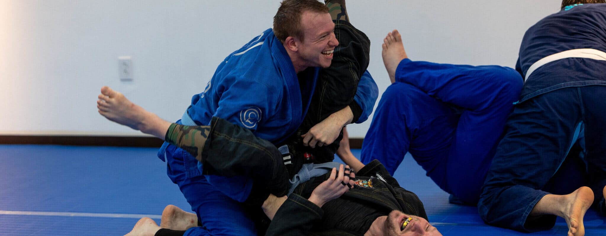 a fun training session as one student practices pinning another, but both are smiling and enjoying the sparring session at wilkes barre mma