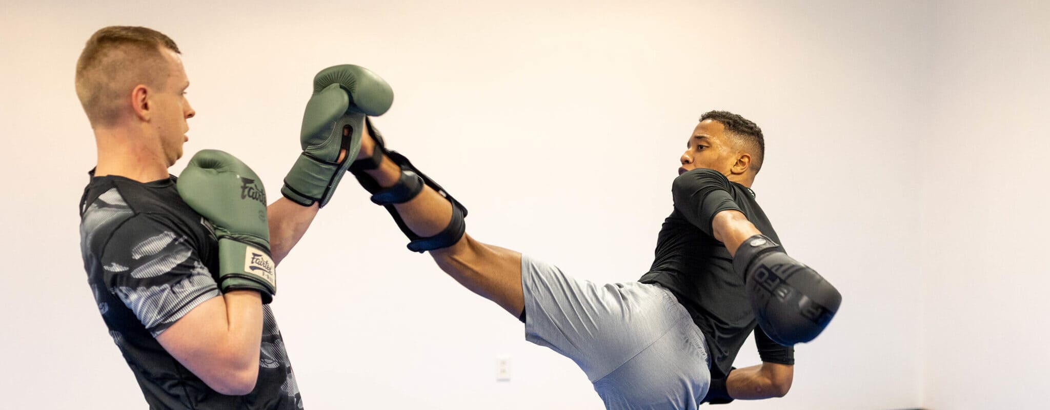 a MMA student leans back to dodge his sparring partners kick at Wilkes Barre MMA gym