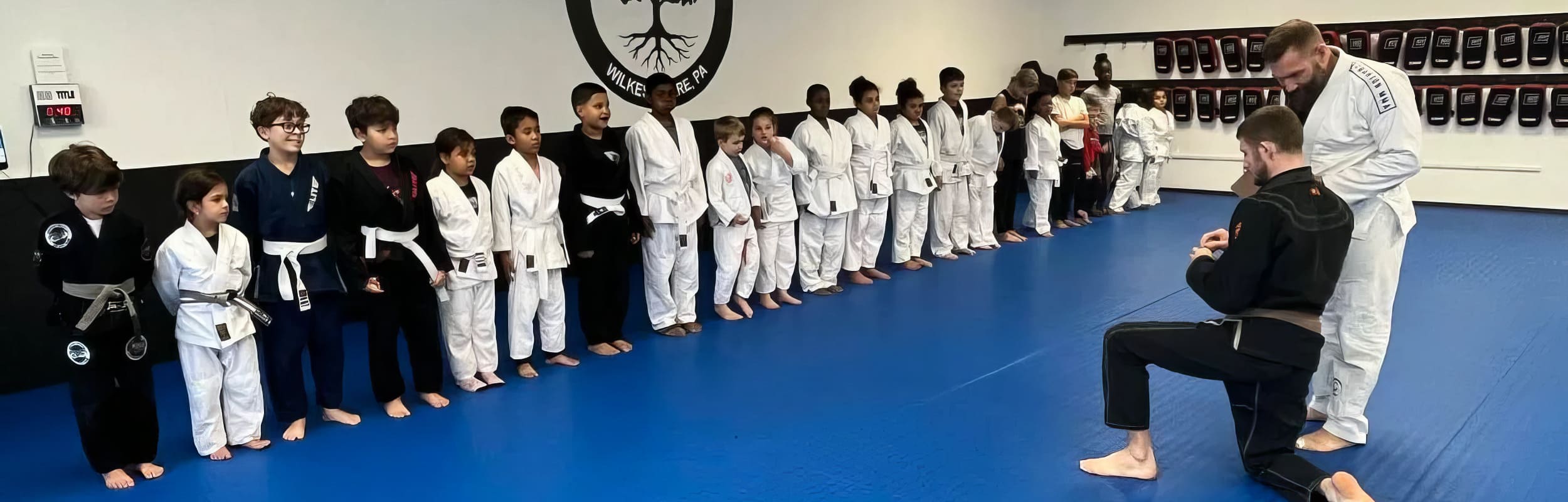 kids attentively listen to their BJJ coach in Wilkes Barre PA