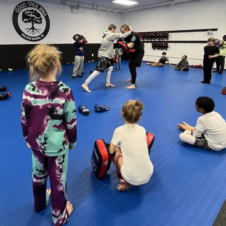 young students attentively pay attention to the lessons of their BJJ instructors